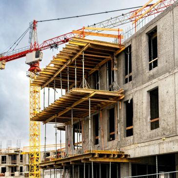 Construction site with a concrete building and a crane.