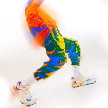Vibrant, colorful motion blur of a person jumping in sporty attire.