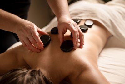 Person receiving hot stone massage on back.