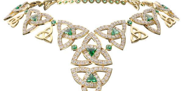 Elegant gold necklace with green gemstones and intricate Celtic-inspired design.