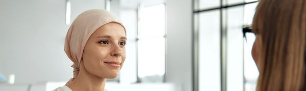 Woman with headscarf smiling in an indoor setting.