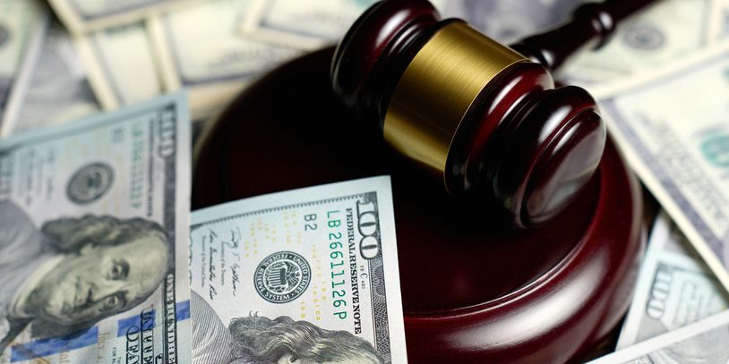 Money on a table with a judge's gavel next to it