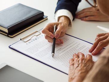 Person explaining contract details with a pen to another individual. ProTrace Process Serving supporting legal teams by serving Nowra and NSW South Coast areas.