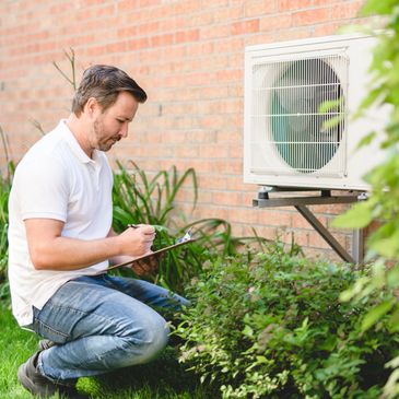 Man inspecting an outdoor air conditioning unit with clipboard.