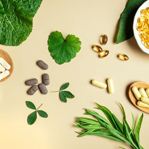 Natural supplements with various capsules and leaves.