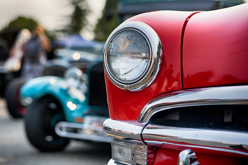 Philippe Defechereux at a classic Mustang car show, surrounded by vintage cars and enthusiasts.