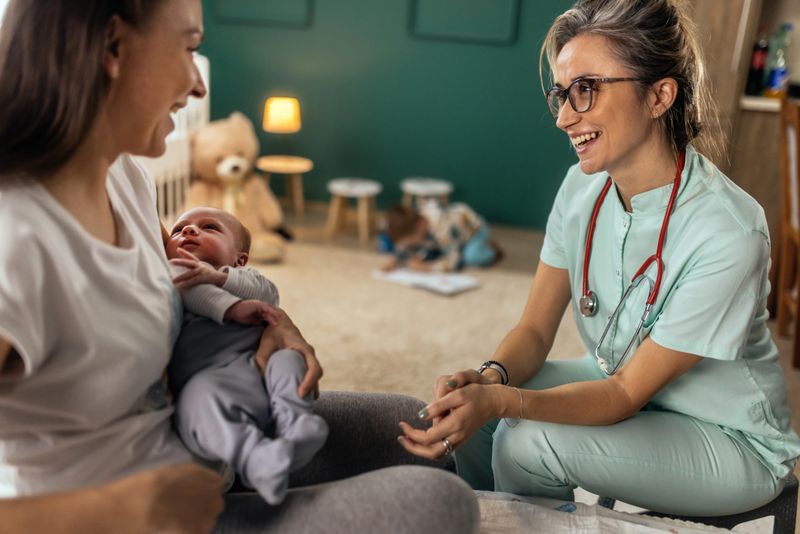 Female doctor at house visit,checking up newborn baby boy