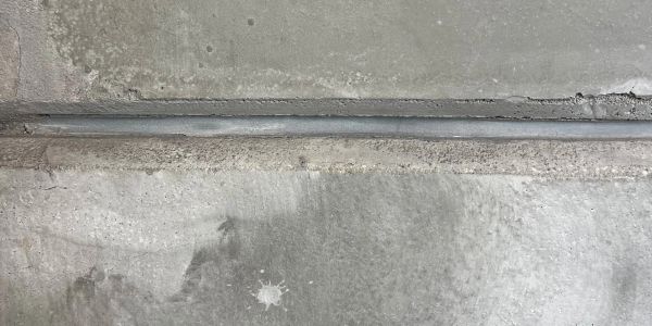 Close-up of concrete slabs with a narrow gap between them.
