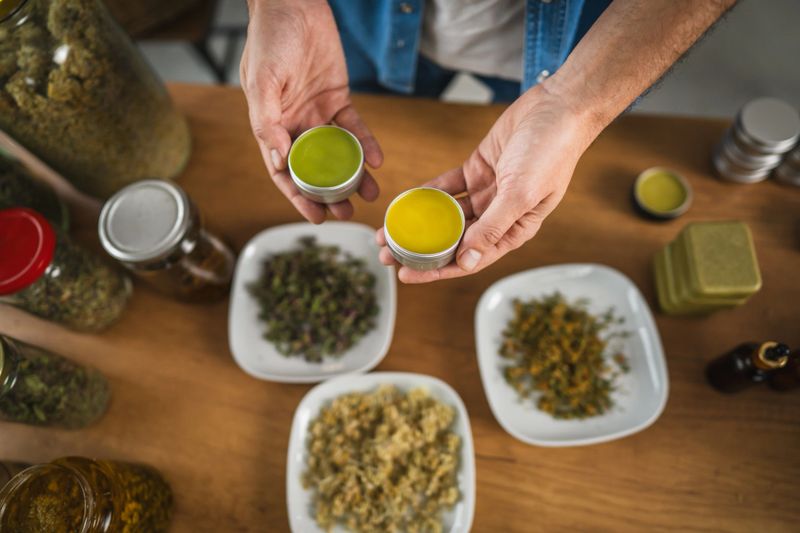 top down view of man hands hold organic natural salve in workshop