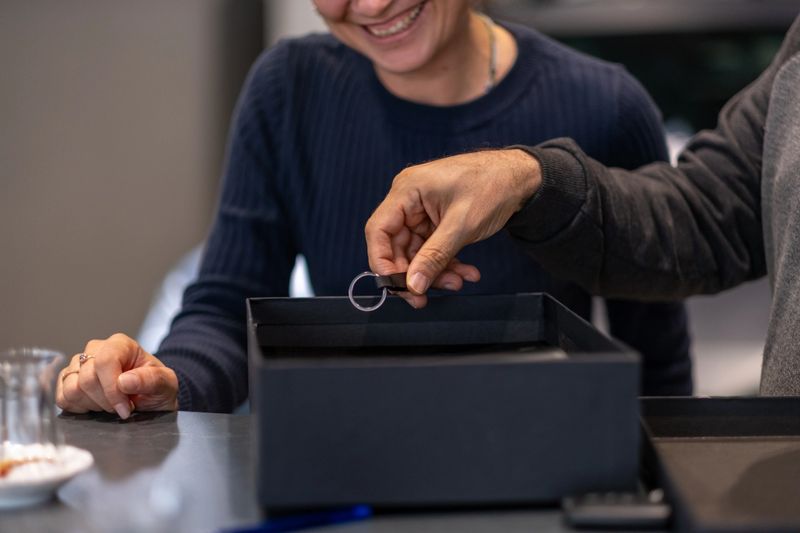Jeweler presents a beautiful ring to a happy customer in a cozy shop, radiating joy and satisfaction