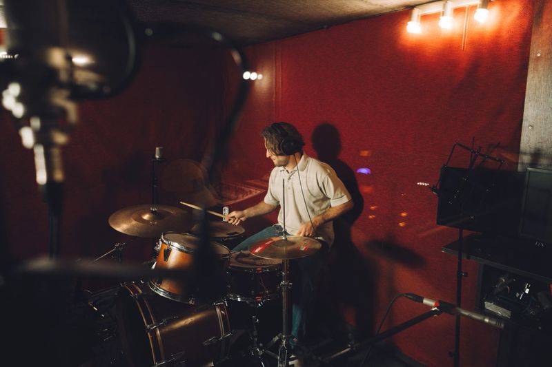 Drummer experimenting with new sounds in a music studio