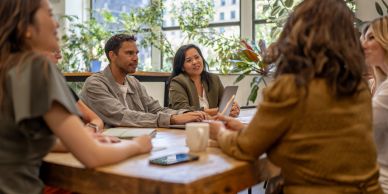 People having a discussion around a table in a bright office.