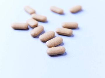 A group of brown capsules scattered on a white surface.