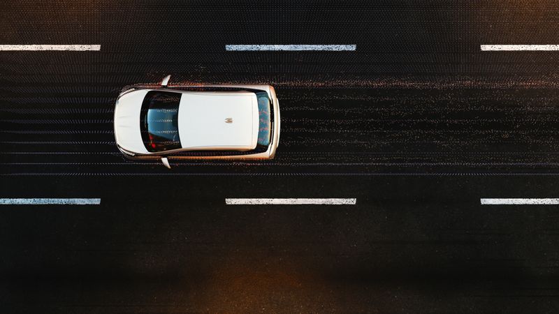 A car driving in the city at night, hitting particles flying away from it. The car design is not based on any real vehicle