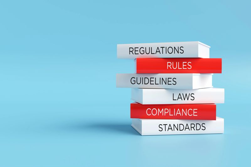 Books forming a stack with words regulations, rules, guidelines, laws, compliance and standards, compliance concept. 3D render.