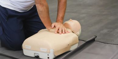 Person performing CPR on a training manikin.