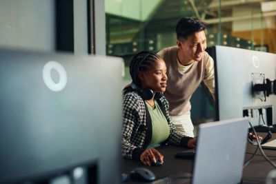 Dos personas trabajando juntas frente a una computadora.