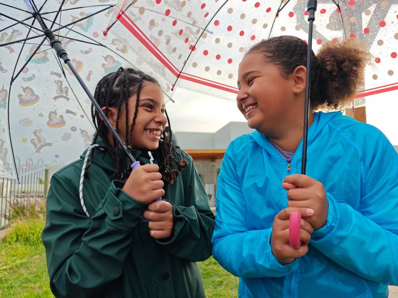 Playful child laughing during a colorful outdoor photoshoot at the park.