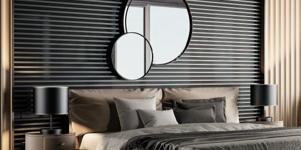 Modern bedroom with beige bed, round mirrors, and black accent wall.