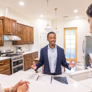 Man speaking to a group in a kitchen.