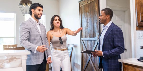 Couple visits real estate agent inside a modern home.