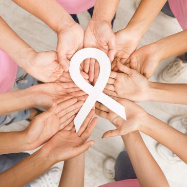 Hands holding a white awareness ribbon together.