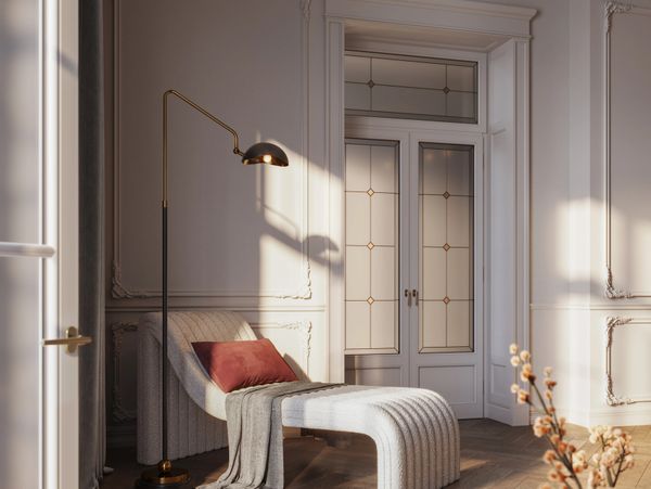 Elegant chaise lounge with a floor lamp and soft natural light in a classic room.