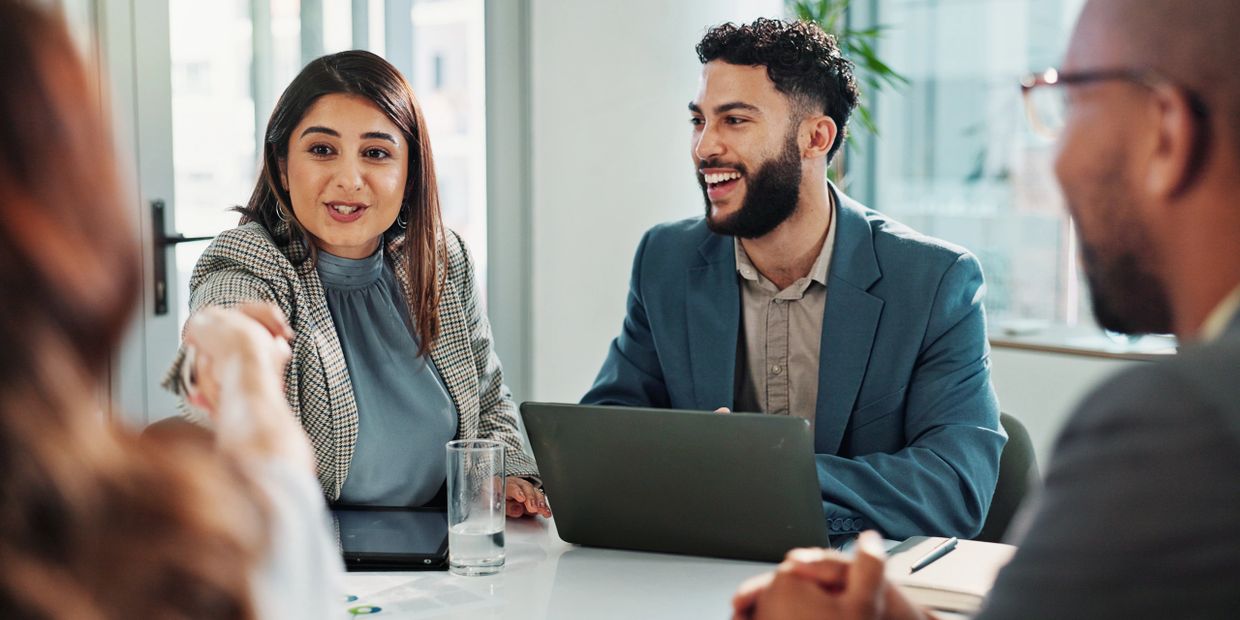 Two professionals shaking hands during a business meeting in an office.