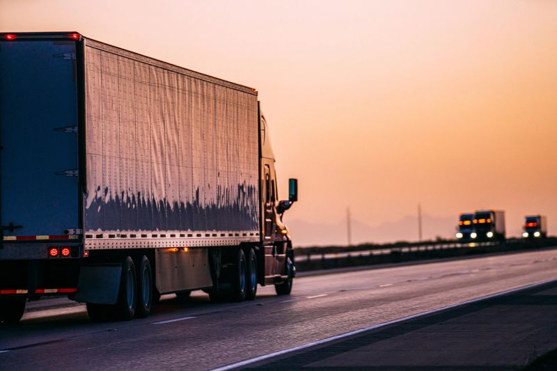 Tractor Trailer Transporting Goods on the Interstate with a Colorful Vibrant Sunrise in a Desert Area East of El Paso, Texas, USA