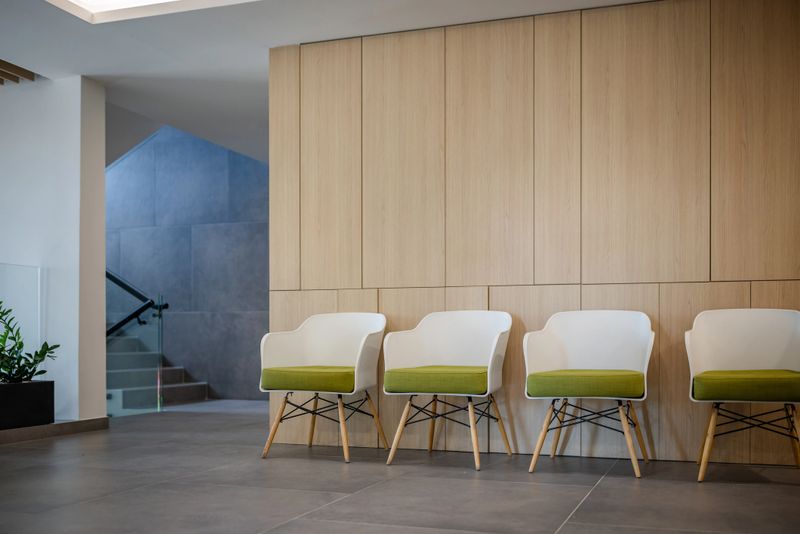 A minimalist waiting area with white chairs, providing a spacious and quiet environment for visitors.