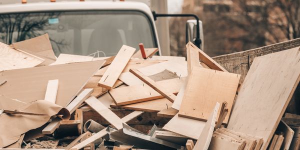 Pile of wooden debris and scrap in a truck bed.