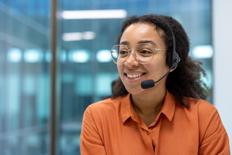 Confident customer support agent wearing headset smiling