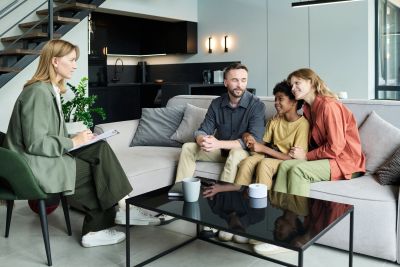 Family meeting with a counselor in a modern living room.