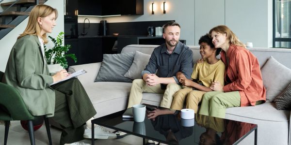 Family counseling session with therapist in modern living room.