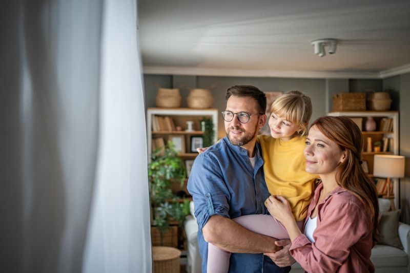 This touching scene shows parents, father and mother, holding their daughter in a warm embrace, showing the strength of family love and connection. All smiling and filled with happiness, they enjoy a moment of closeness that symbolizes the safety, love and protection that family provides. Photography ideal for themes that explore family values, interpersonal relationships, love and emotional connection within a family.