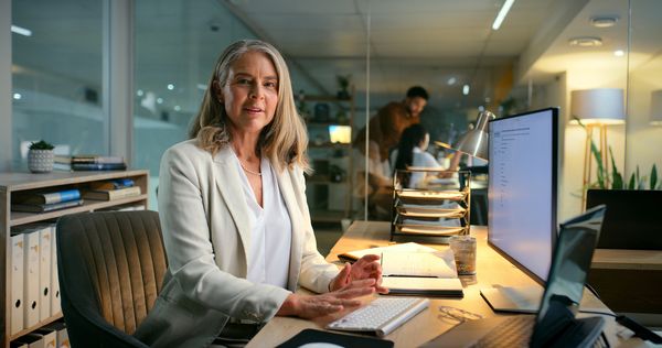 Confident businesswoman working late in a modern office environment.