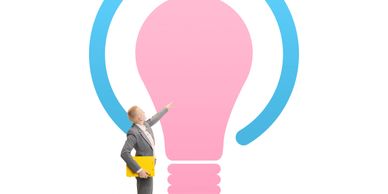 Businesswoman pointing at a large pink light bulb icon.