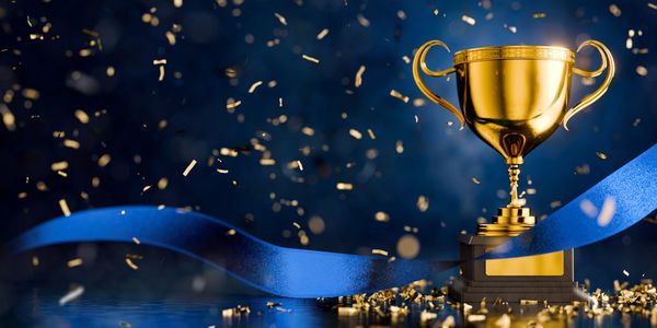 Golden trophy with blue ribbon and confetti.