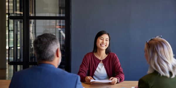 Woman smiling during interview with two people.