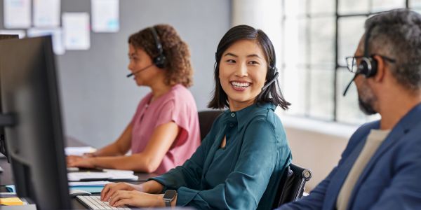 Customer service team members wearing headsets at work.
