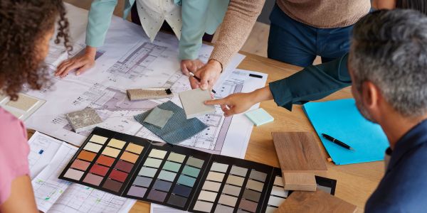 Group discussing color and material samples over architectural plans.