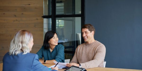 Three colleagues engaged in a friendly meeting at a modern office.