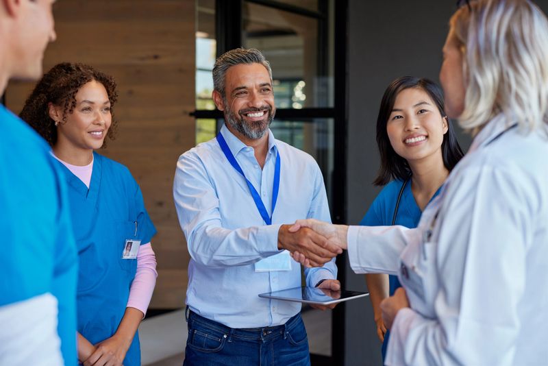 Healthcare professionals greeting pharmaceutical representative. Doctors and healthcare team discussing medical advancements with an indian representative. Medical staff collaborating on healthcare solutions and close a deal with a business handshake.