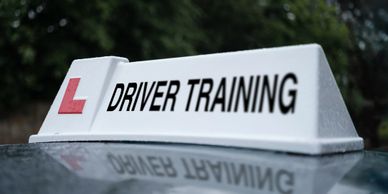 A driving instructors roof box showing L plate