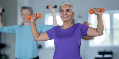 Senior women exercising with dumbbells in a fitness class.