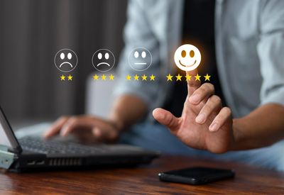 Person selects a five-star happy face rating on a digital interface.
