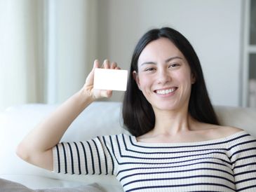 Femme heureuse montrant son abonnement Milady, exprimant la joie de rejoindre un cercle de femmes.