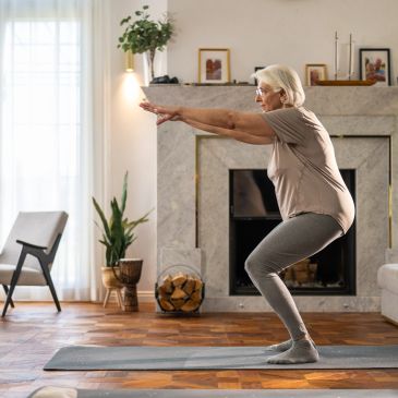 Elderly woman doing yoga at home.