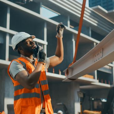 A construction worker securing a large beam.  