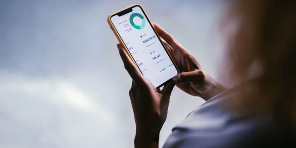 Person analyzing financial data on a smartphone screen.